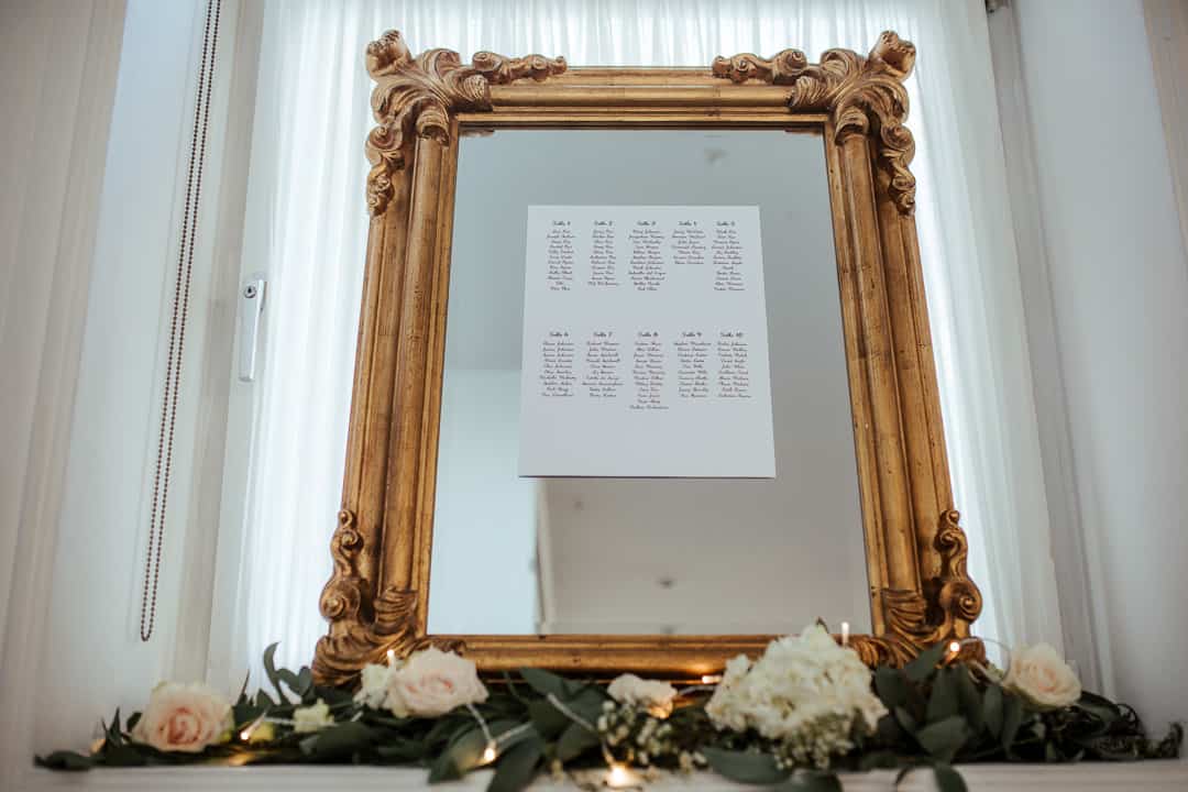 wedding at fallon and byrne table plan on a gilded mirror