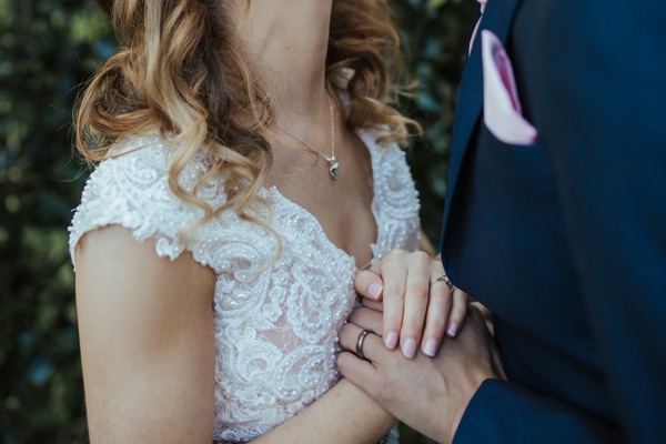 close up of bride and groom holding hands