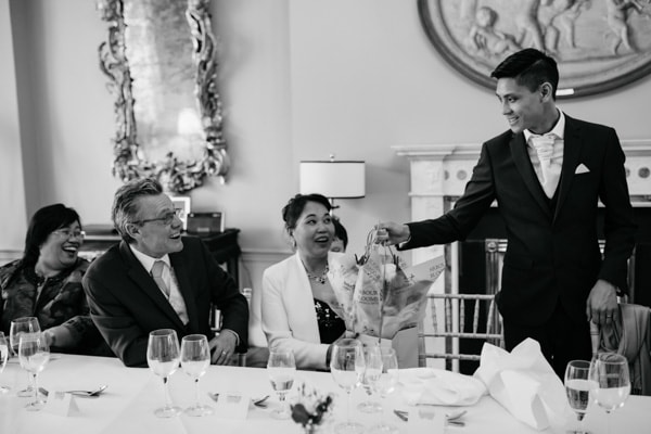 groom presenting flowers to mother of the bride
