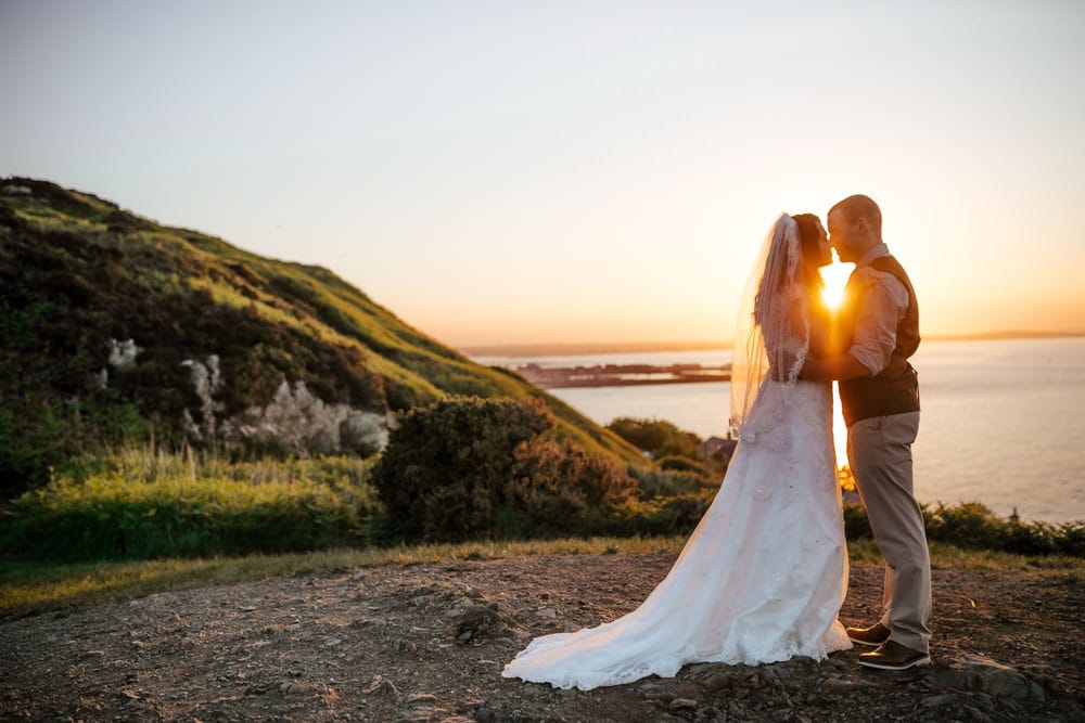 couple kissing in the setting sun on howth cliffs dublin ireland