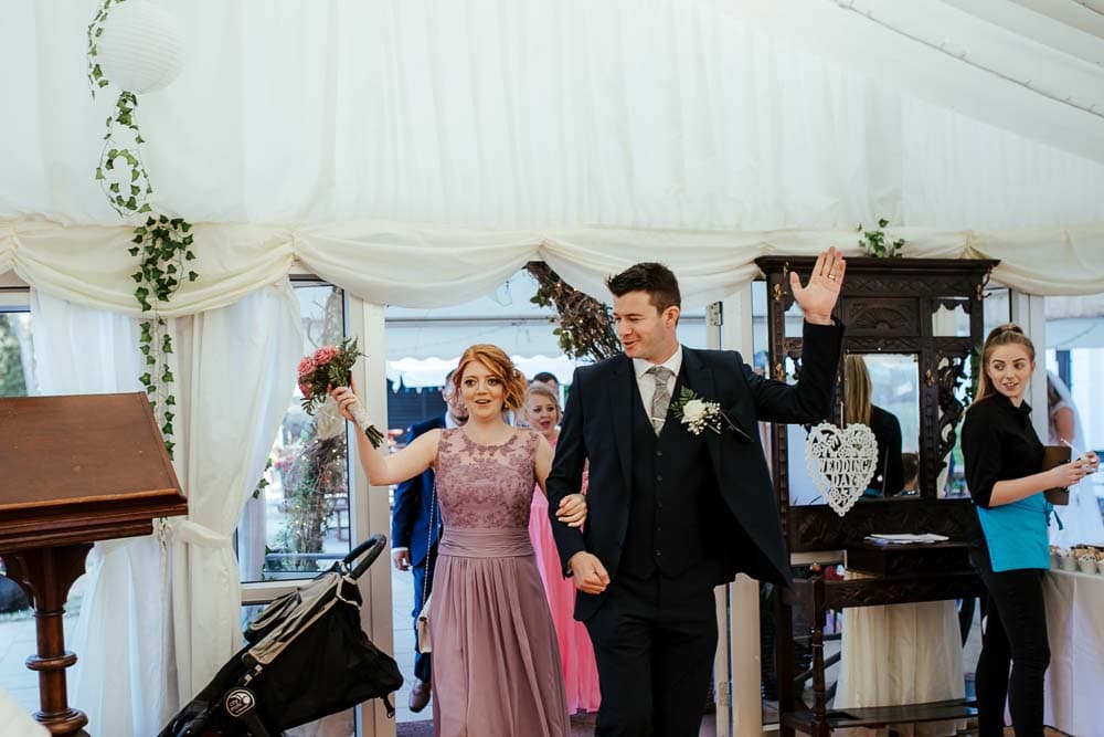 bridesmaid and groomsman entering wedding reception