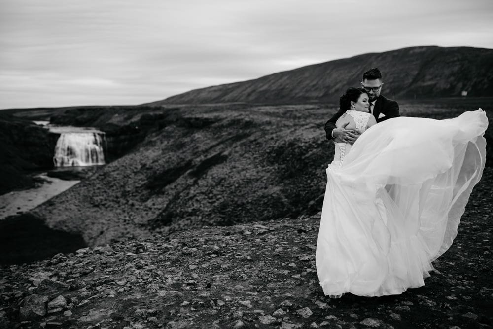 windy wedding in iceland couple by waterfall