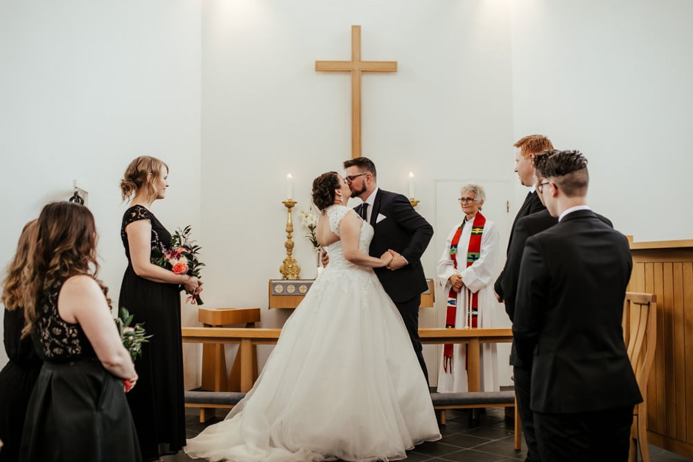 bride and groom first kiss in traditional church ceremony wedding in iceland