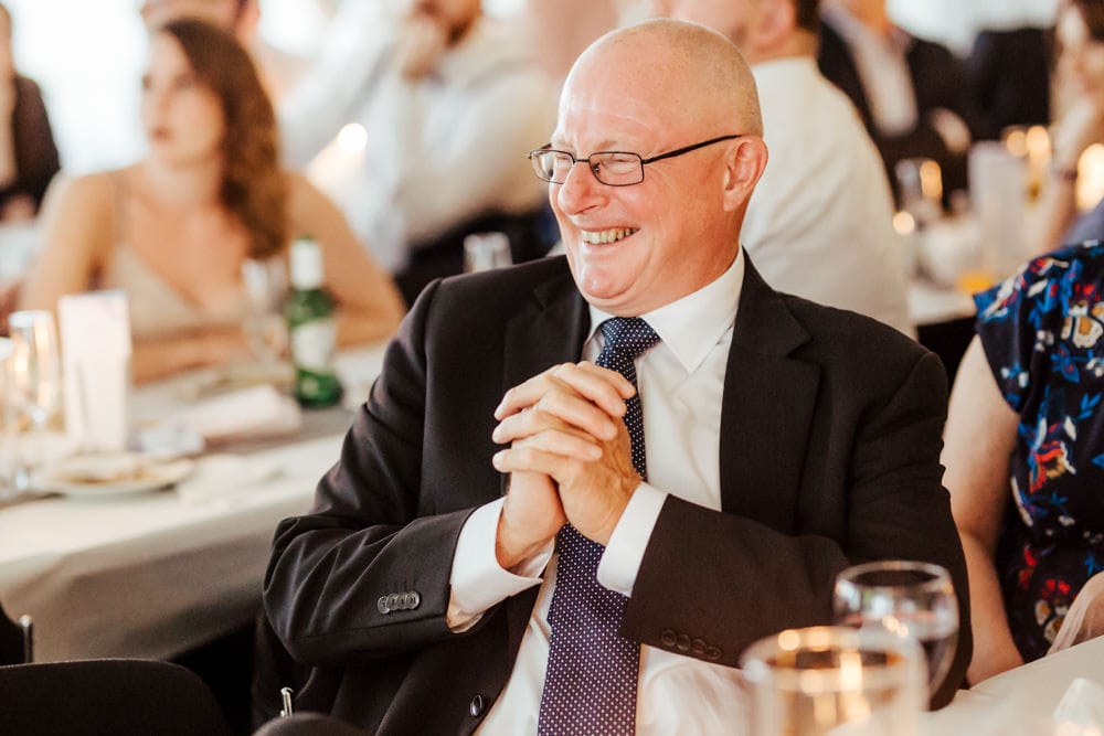 father of the bride laughing during wedding speeches