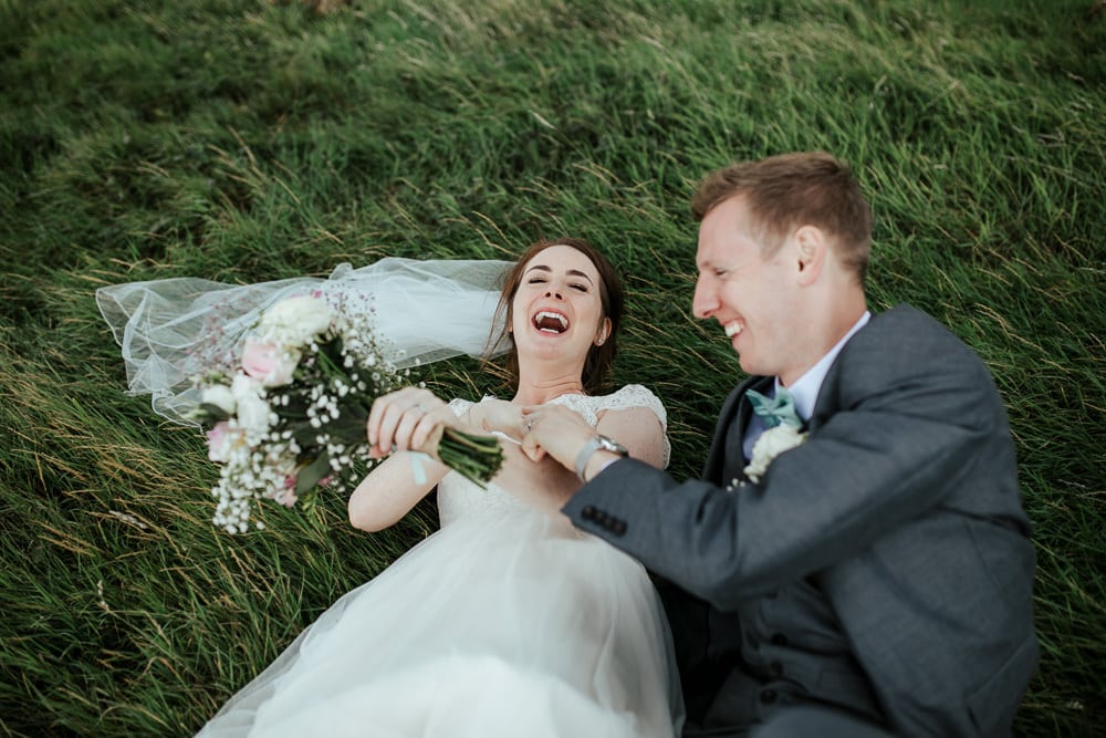 bride and groom fell of the swing laughing