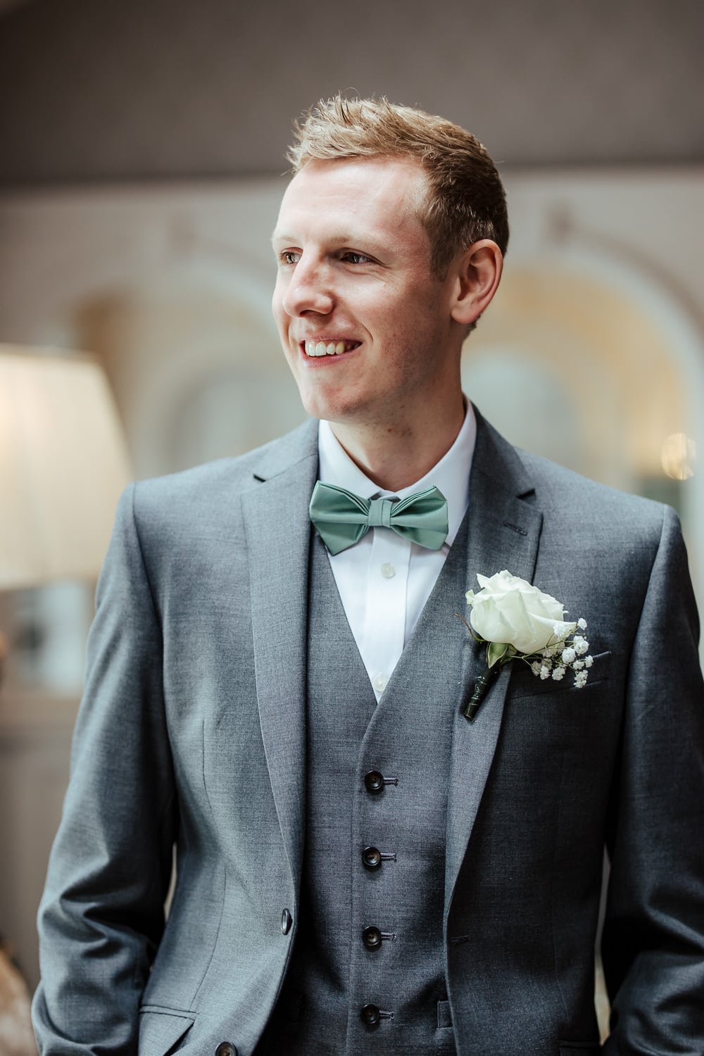 portrait of the groom in grey suit mint bow tie