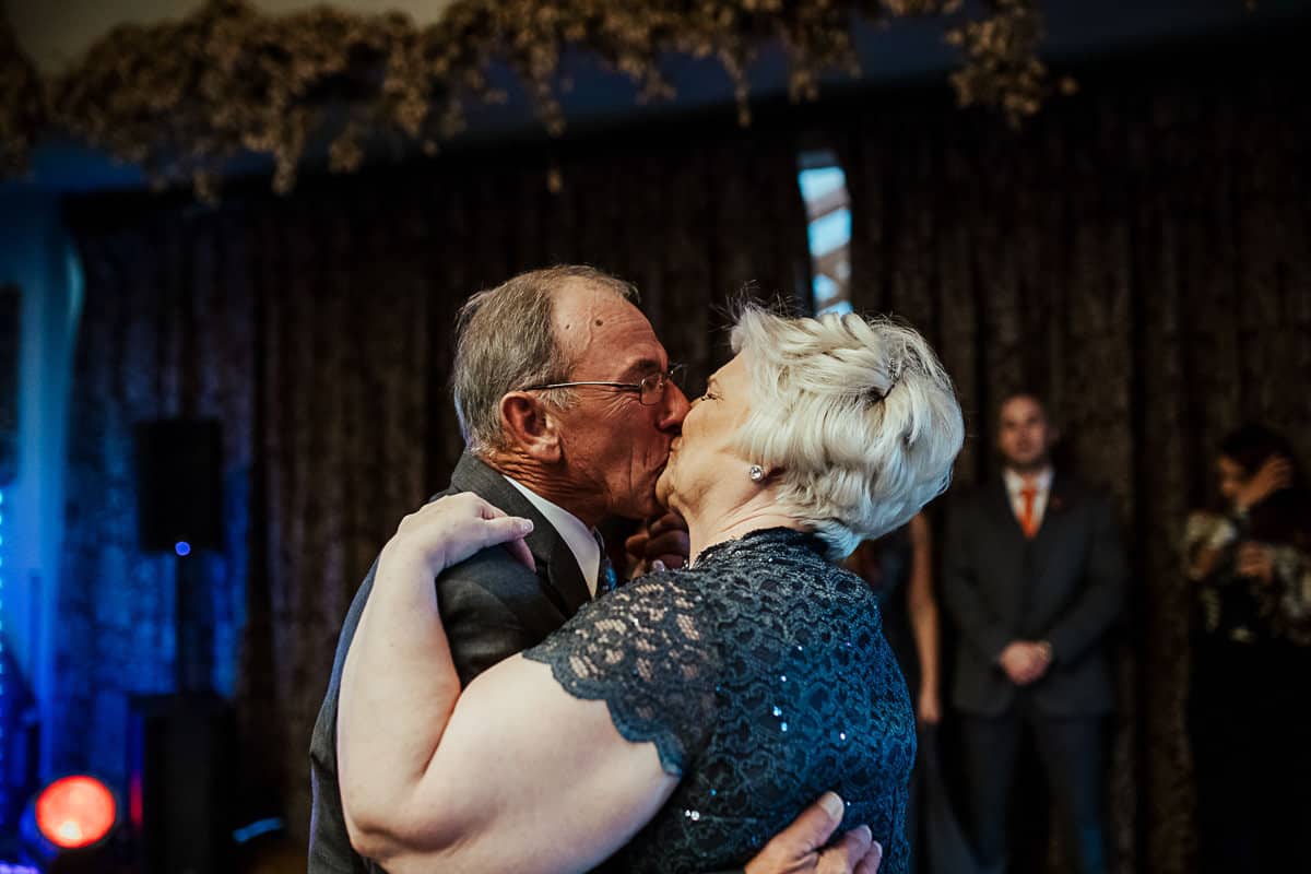 grandparents sharing a kiss at their wedding anniversary