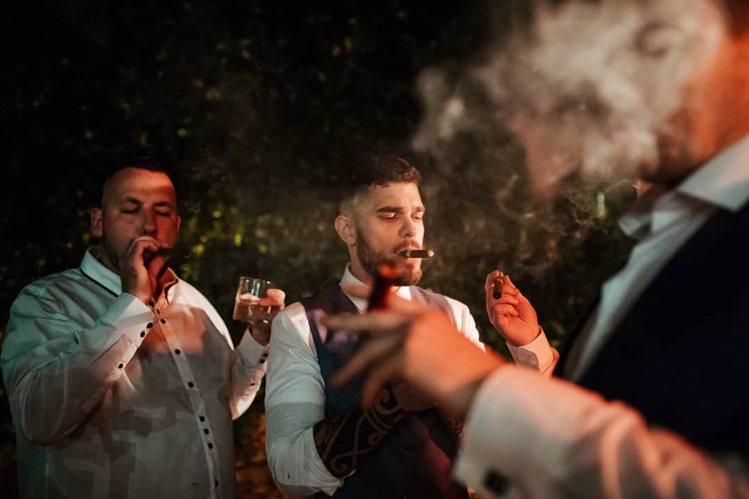 groom smoking cuban cigars on the evening of his wedding