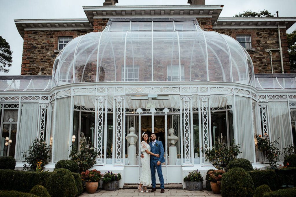 wedding couple in front of the conservatory at marlfield house