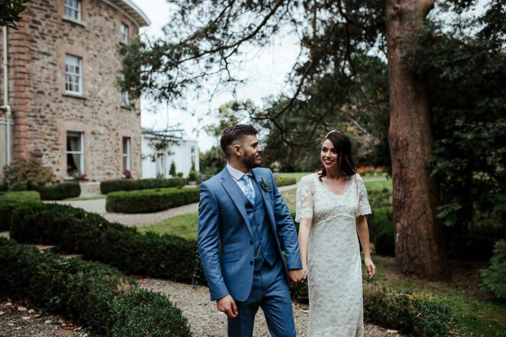 bride and groom taking a walk through marlfield house gardens in autumn wedding photographer ireland