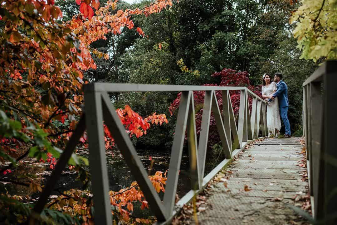 bride and groom on the bridge at marlfield house gardens autumn wedding photographer ireland
