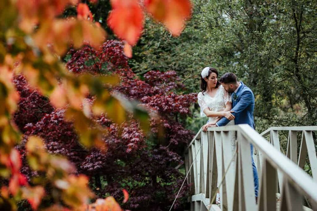 bride and groom on the bridge at marlfield house gardens autumn wedding photographer ireland