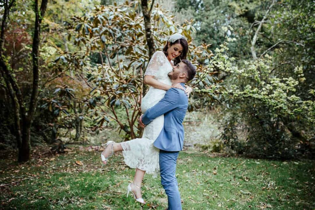 groom lifting up the bride during wedding portraits