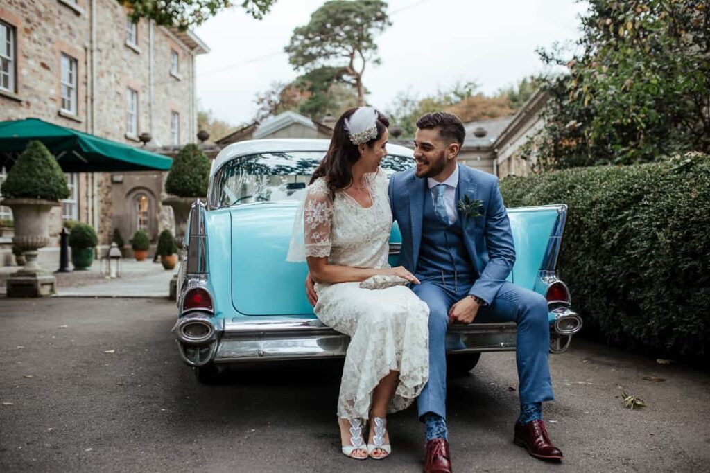 bride and groom sitting on the back of american vintage wedding car blue chevy ireland
