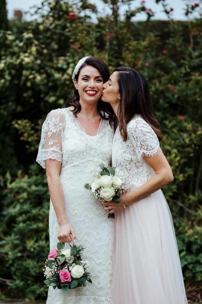 bride's sister kissing her on her wedding day
