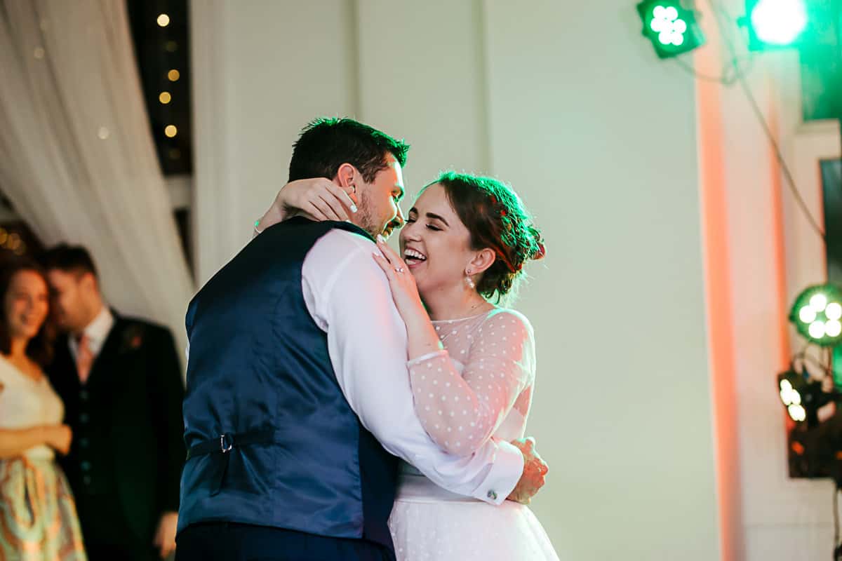 bride and groom laughing during their fist dance