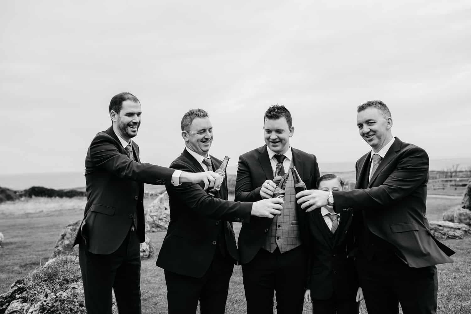 groom and his groomsmen enjoying a beer personalized beer bottles