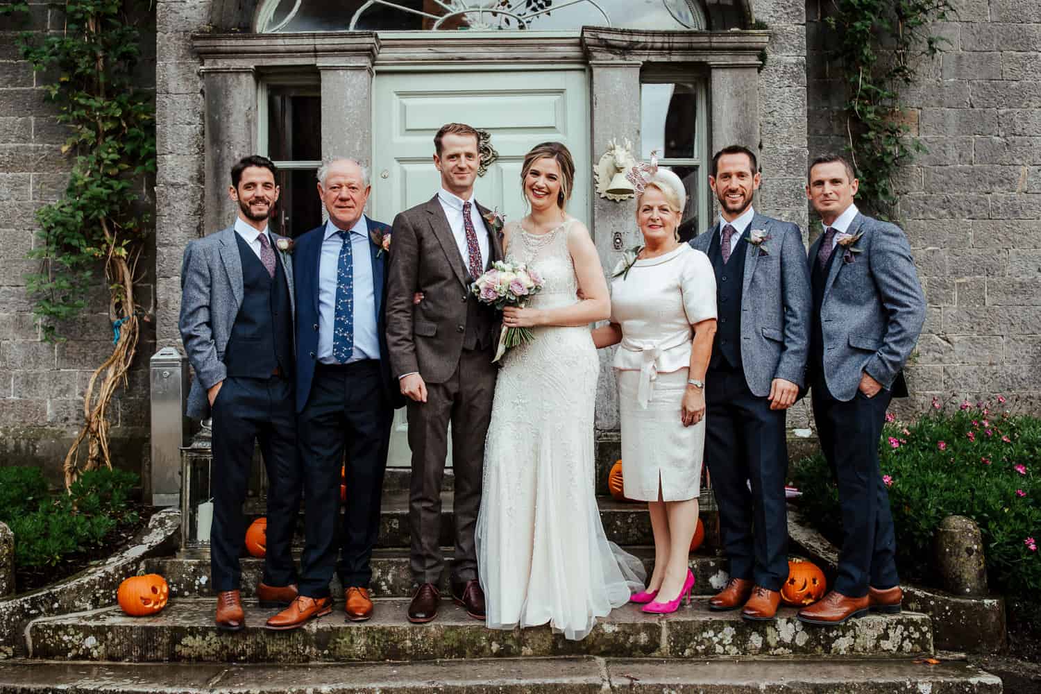 family wedding photo at the steps of the millhouse 